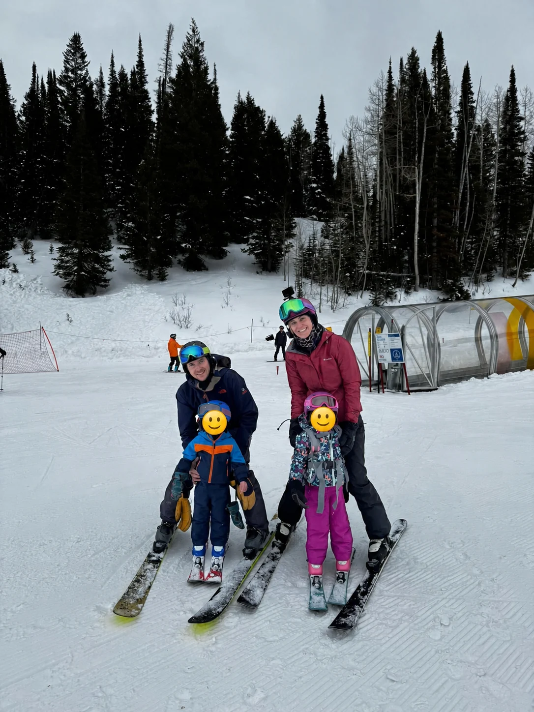 Vanessa skiing with her family; the children’s faces are covered with smiley stickers
